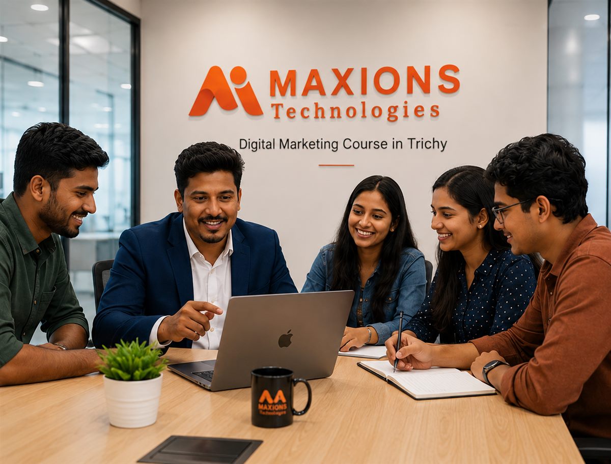 Mentor guiding a small group of digital marketing students around a laptop at Maxions Technologies